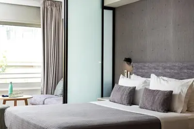 a bedroom with a large bed and a window at Enattica Suites in Athens
