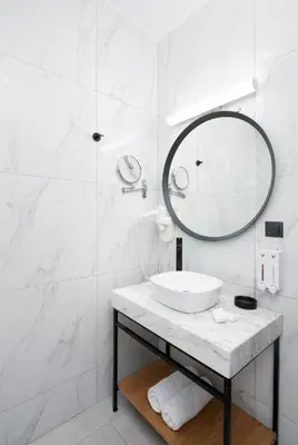 a white bathroom with a sink and a mirror at Enattica Suites in Athens