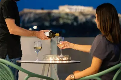 a man pouring a woman a glass of wine at Enattica Suites in Athens