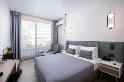 a bedroom with a bed and a desk and a chair at Enattica Suites in Athens