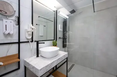 a white bathroom with a sink and a shower at Enattica Suites in Athens
