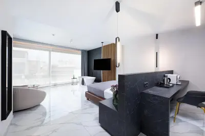 a bathroom with a tub and a bed and a sink at Enattica Suites in Athens