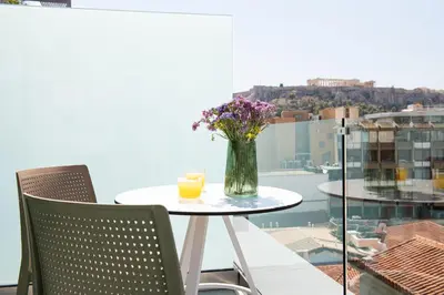 a table with a vase of flowers and two candles at Enattica Suites in Athens