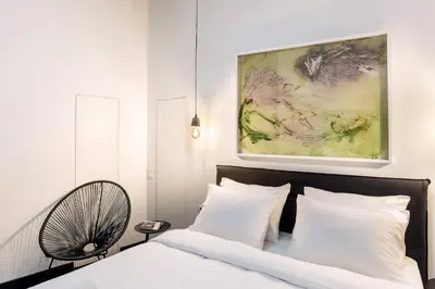 a bedroom with a bed and a painting on the wall at Nin&Bau Sarri 2 in Athens
