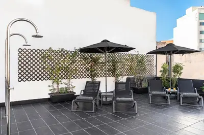 a patio with chairs and umbrellas on a building at Nin&Bau Sarri 2 in Athens