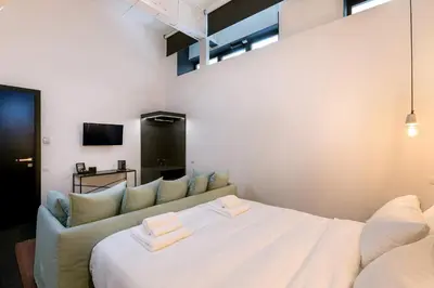 a bedroom with a large white bed and a couch at Nin&Bau Sarri 2 in Athens