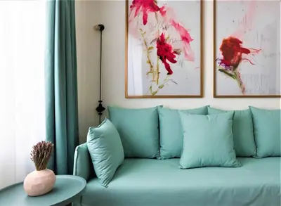 a blue couch in a living room with paintings on the wall at Nin&Bau Sarri 2 in Athens