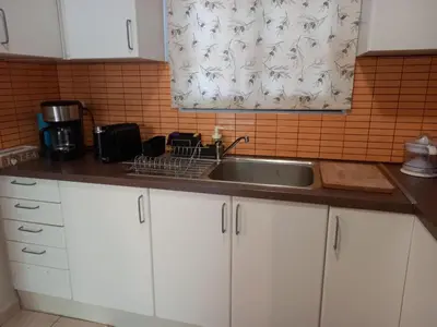 a kitchen with white cabinets and a sink at Helen's Welcoming & cozy flat in Koropíon