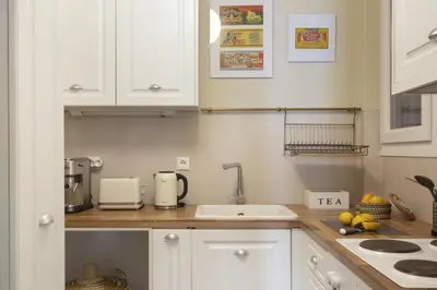 a kitchen with white cabinets and a sink at Little gem 2 mins from Acropolis Museum in Athens