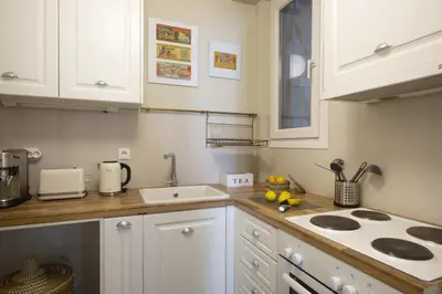 a kitchen with white cabinets and a stove top oven at Little gem 2 mins from Acropolis Museum in Athens