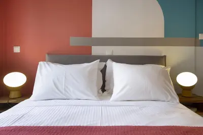 a bed with two white pillows and two lamps at Little gem 2 mins from Acropolis Museum in Athens