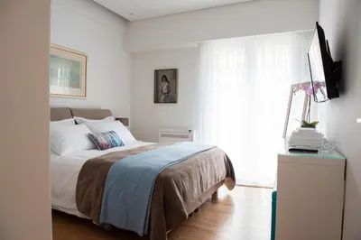 a bedroom with a bed and a tv and a window at Katia Modern Apartment in Athens in Athens