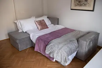a bed with a blanket and a chair in a room at Katia Modern Apartment in Athens in Athens