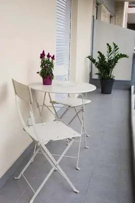 a white table and chairs in an office with flowers at Katia Modern Apartment in Athens in Athens