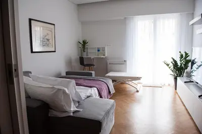 a white room with a bed and a table at Katia Modern Apartment in Athens in Athens