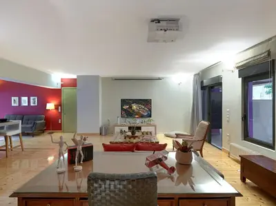 a living room with a couch and a table at Koukaki garden escape child friendly apartment in Athens