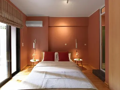 a bedroom with a large bed with red walls at Koukaki garden escape child friendly apartment in Athens