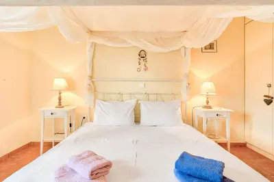 a bedroom with a white bed with two night stands at Villa Casa Del Sol with private pool in Sounio