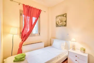 a small bedroom with a bed and a window at Villa Casa Del Sol with private pool in Sounio
