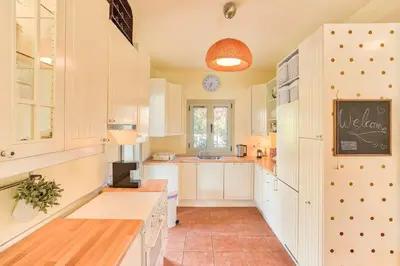 a kitchen with white cabinets and a chalkboard on the wall at Villa Casa Del Sol with private pool in Sounio