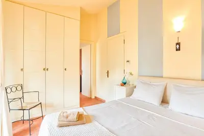 a bedroom with a large white bed and a chair at Villa Casa Del Sol with private pool in Sounio