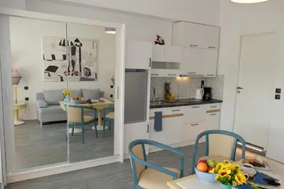 a kitchen with white cabinets and a table with a bowl of fruit at STUDIO ANASTASIA in Athens