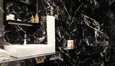 a bathroom with a sink and a black marble wall at STUDIO ANASTASIA in Athens