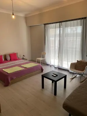 a bedroom with a bed and a table and a couch at Aris Apartment in Athens