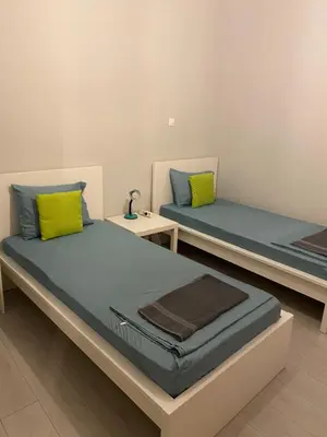 two beds in a room with yellow and blue pillows at Aris Apartment in Athens