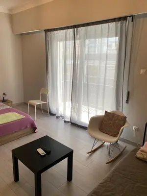 a living room with a bed and a chair and a table at Aris Apartment in Athens