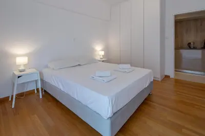 a bedroom with a white bed with two towels on it at Hippocrates - Faliro deluxe apartment in Athens