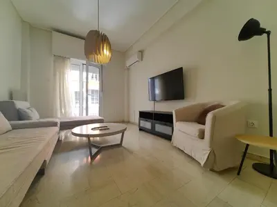 a living room with a couch and a tv at Demetra - Koukaki center apartment in Athens
