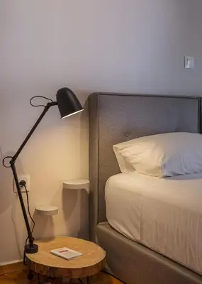 a bedroom with a bed and a lamp and a table at Demetra - Koukaki center apartment in Athens