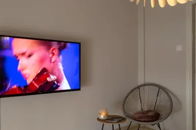 a flat screen tv hanging on a wall with a chair at Demetra - Koukaki center apartment in Athens