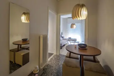 a living room with two tables and a mirror at Demetra - Koukaki center apartment in Athens