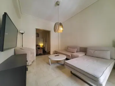 a living room with a couch and a table at Demetra - Koukaki center apartment in Athens