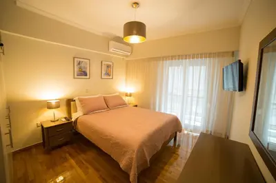 a bedroom with a bed and a tv and a window at Ivannas dream house in Athens