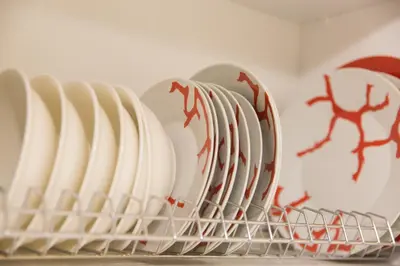a row of white plates in a dish rack at Ivannas dream house in Athens