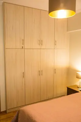 a bedroom with wooden cabinets and a bed at Ivannas dream house in Athens