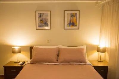 a bedroom with a bed with two lamps and two pictures at Ivannas dream house in Athens