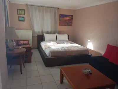 a bedroom with a bed and a table and a couch at Antonia family house near Airport in Porto Rafti