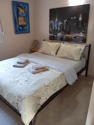 a bed with two towels on it in a bedroom at Antonia family house near Airport in Porto Rafti