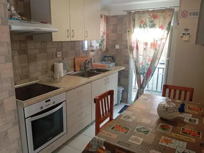 a kitchen with a table and a sink and a counter top at Antonia family house near Airport in Porto Rafti