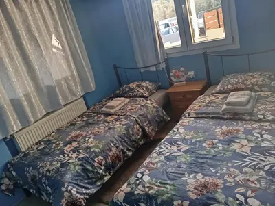two beds in a room with blue walls at Antonia family house near Airport in Porto Rafti