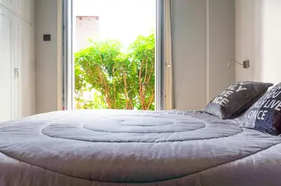 a large bed in a room with a large window at The Burton Luxury 1BR in Plaka, Athens in Athens