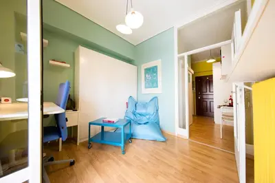a room with a blue chair and a desk at Startupper's Pad in real Athenian neighbourhood in Athens