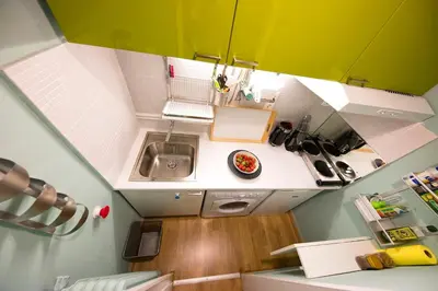 an overhead view of a small kitchen with green and white cabinets at Startupper's Pad in real Athenian neighbourhood in Athens