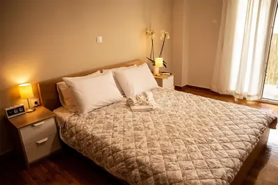 a bedroom with a large bed with two night stands and two lamps at Your apartment in Athens (Next to Metro & Acropolis) in Athens