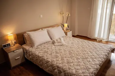 a bedroom with a bed and two lamps and a window at Your apartment in Athens (Next to Metro & Acropolis) in Athens