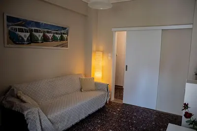 a living room with a couch and a painting on the wall at Your apartment in Athens (Next to Metro & Acropolis) in Athens